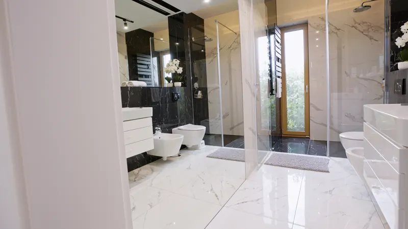 Marmurowa łazienka z kabiną walk-in i czarną armaturą